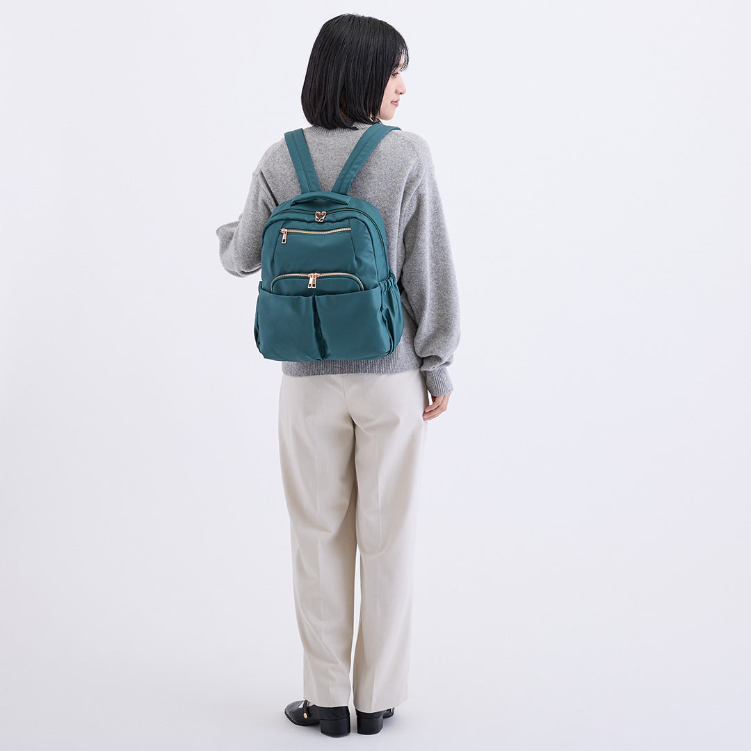 グリーンナイロンリュックを背負う女性