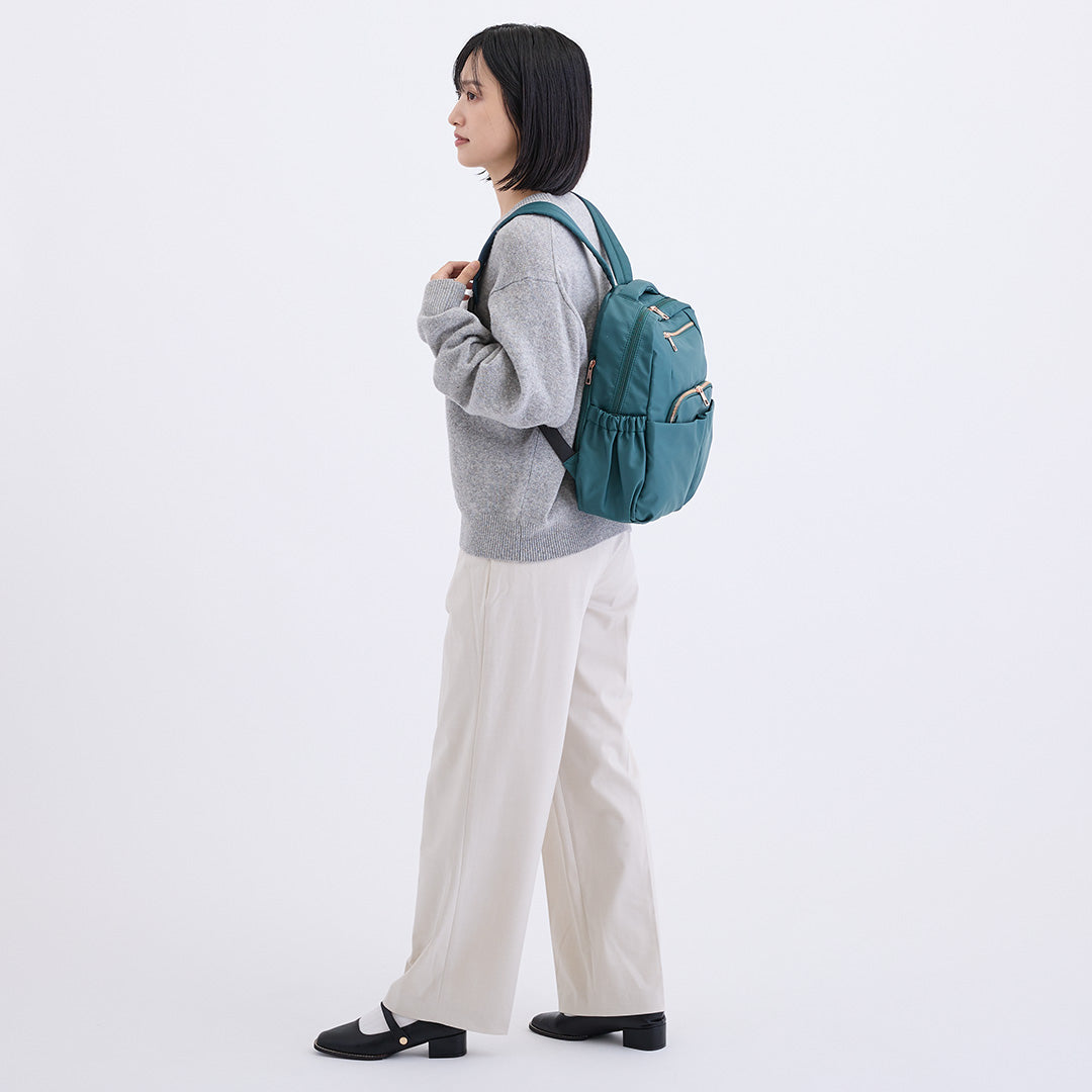 グリーンナイロンリュックを背負う女性