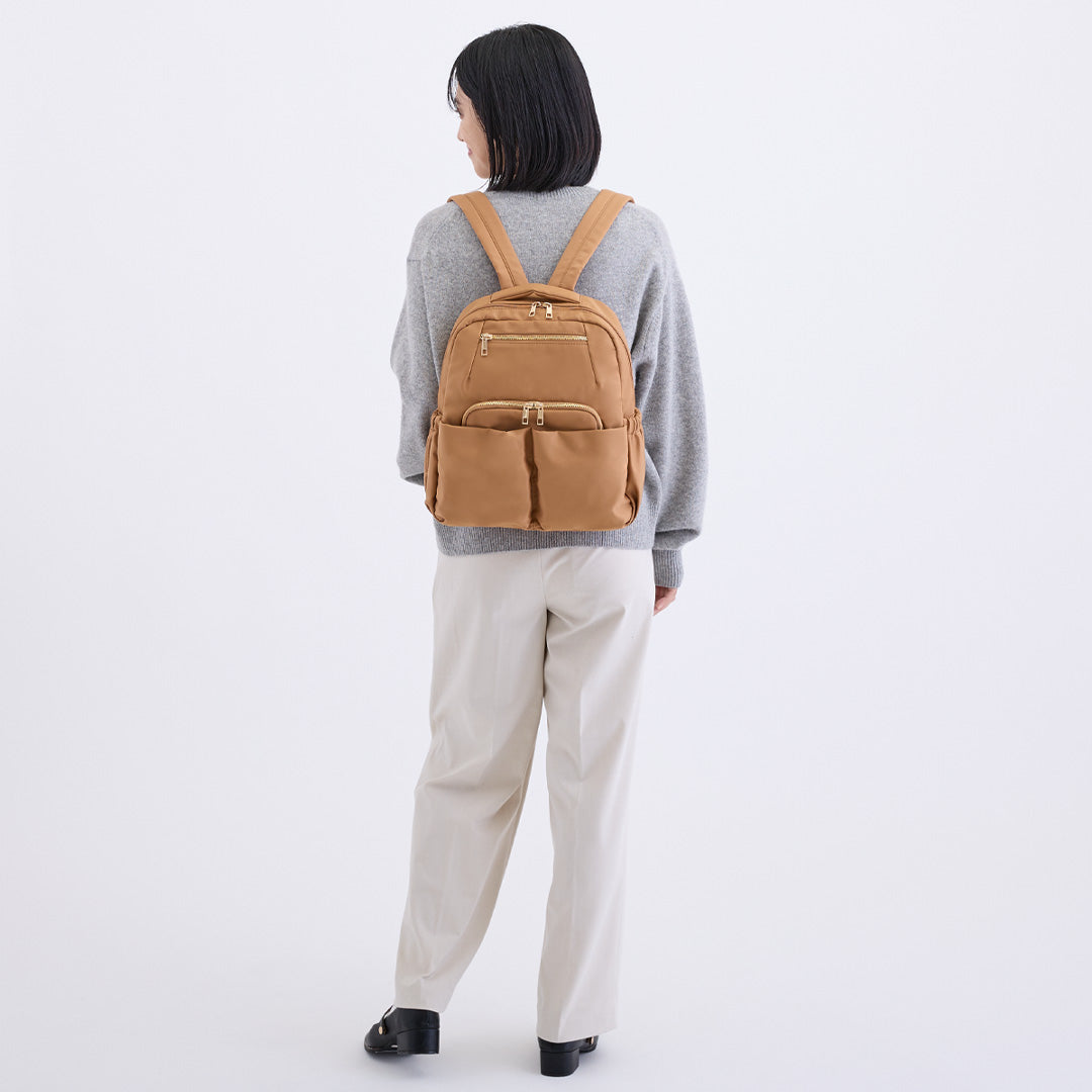 ブラウンナイロンリュックを背負う女性