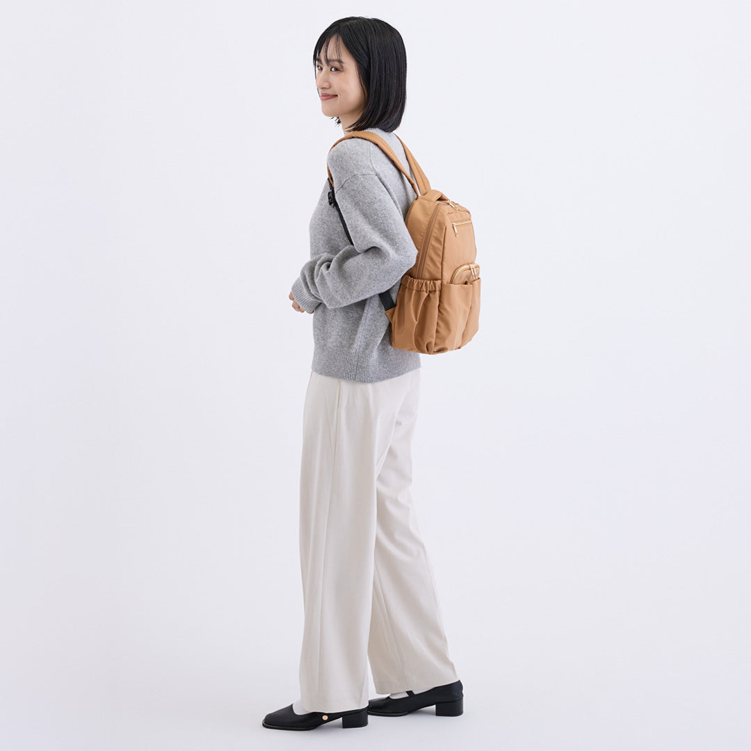 ブラウンナイロンリュックを背負う女性