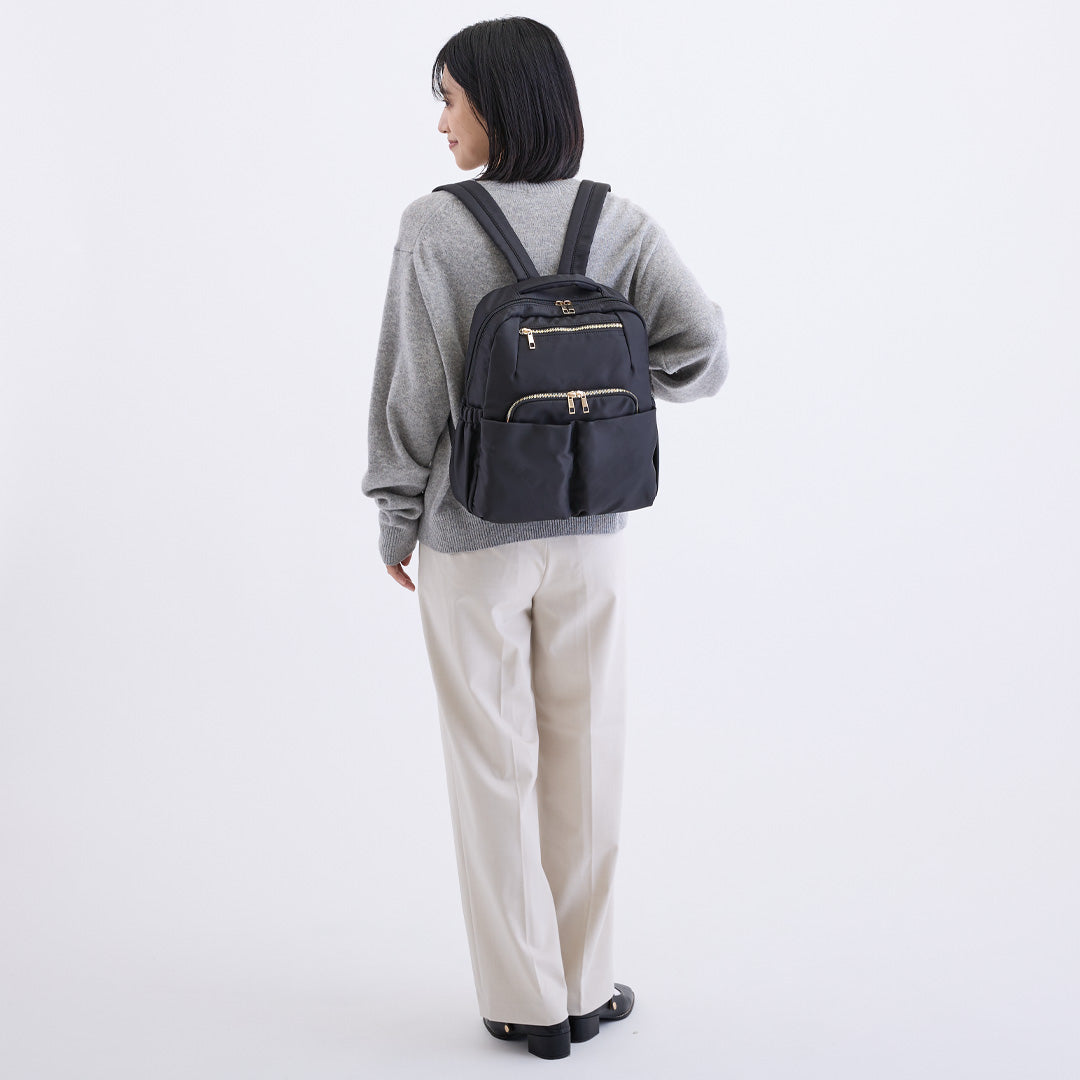 ブラックナイロンリュックを背負う女性