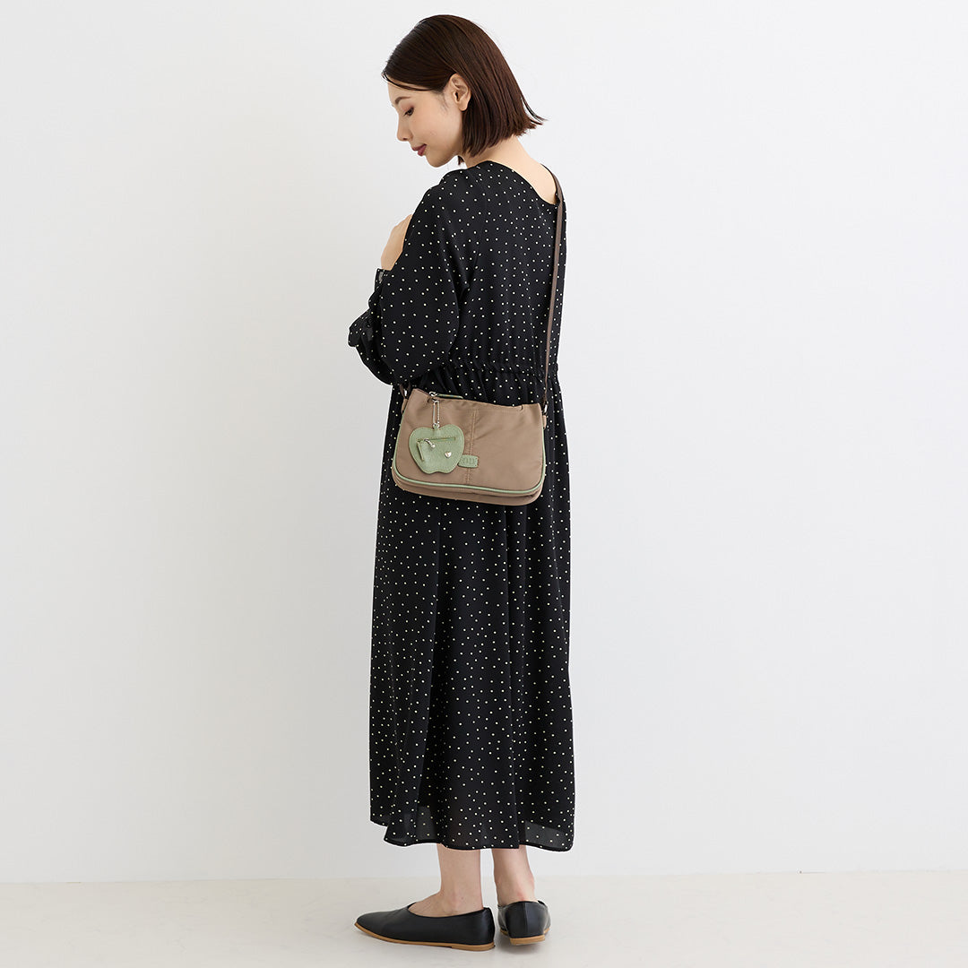 シワナイロンリンゴチャーム付きショルダーバッグミニ ベージュ を斜め掛けした女性の着用イメージ