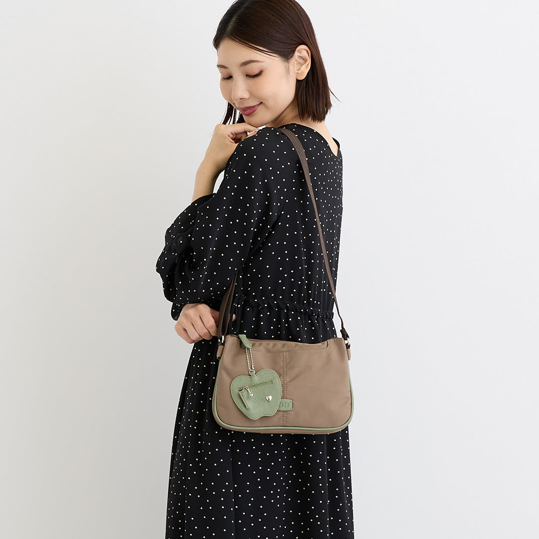 シワナイロンリンゴチャーム付きショルダーバッグミニ ベージュ を肩掛けした女性の着用イメージ