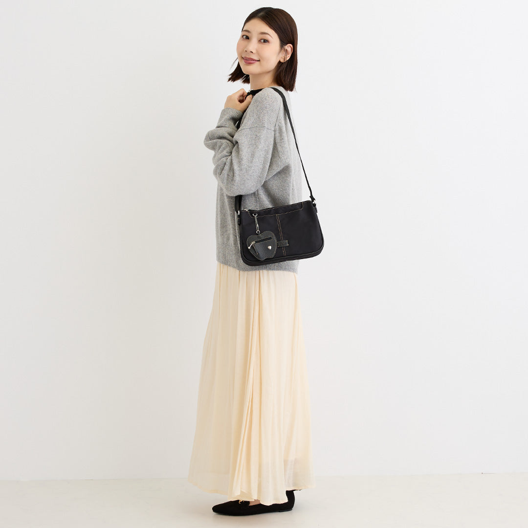 シワナイロンリンゴチャーム付きショルダーバッグミニ ブラック を肩掛けした女性の着用イメージ