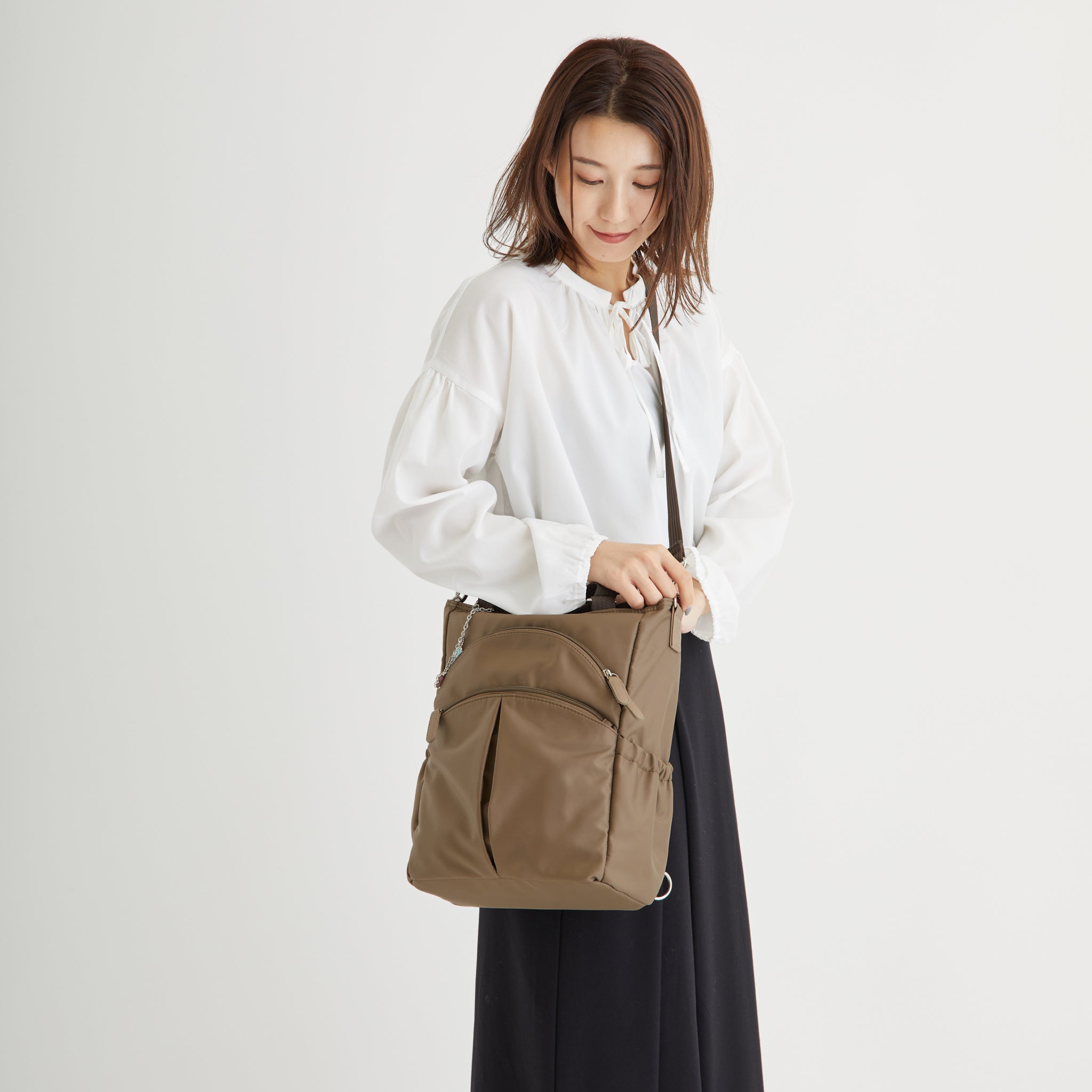 はっ水ナイロン花チャーム付き4wayバッグ トープを肩掛けした女性モデル